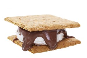 Smores: graham wafer crackers with melted marshmallows and chocolate. This camping favorite is prepared over an open flame and makes a great treat.