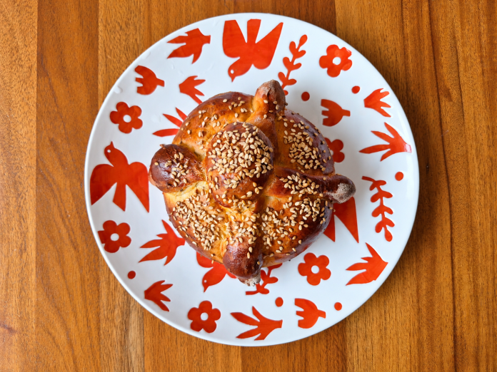 Pan-de-muerto-con-ajonjoli-sobre-plato-artesanal